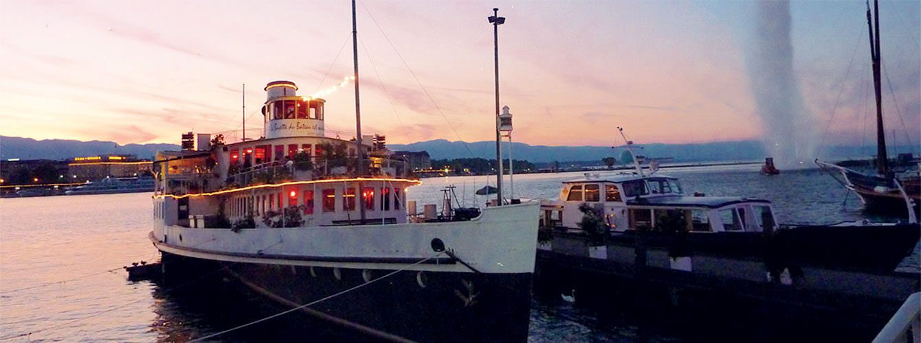 A sunset view of the Bateau Genève with the Jet d'Eau and the Jura as a backdrop